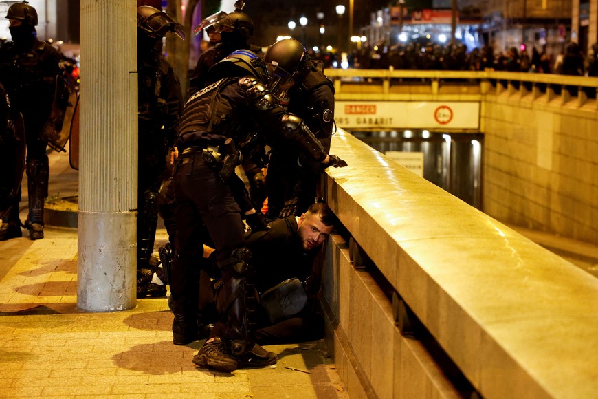 FILE PHOTO: Police hold down a young person during the fifth night of protests following the death of Nahel, a 17-year-old teenager killed by a French police officer in Nanterre during a traffic stop, in the Champs Elysees area, in Paris, France, July 2, 2023. REUTERS/Juan Medina/File Photo