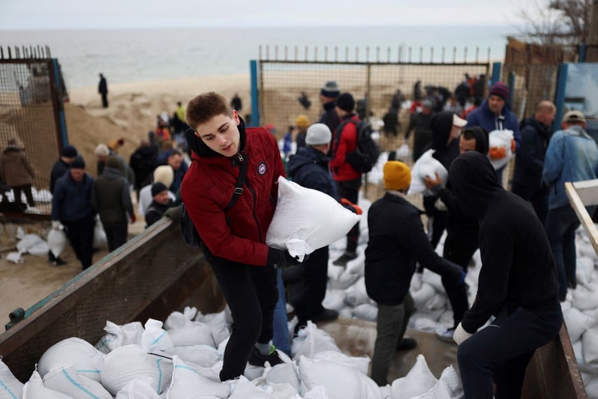 Locals carry sandbags, filled with sand from Sobachyy beach, to bolster the city's defences, as Russia's invasion of Ukraine continues in Odessa, Ukraine, March 14, 2022. REUTERS/Nacho Doce