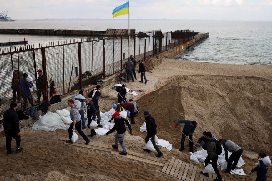 Locals carry sandbags, filled with sand from Sobachyy beach, to bolster the city's defences, as Russia's invasion of Ukraine continues in Odessa, Ukraine, March 14, 2022. REUTERS/Nacho Doce