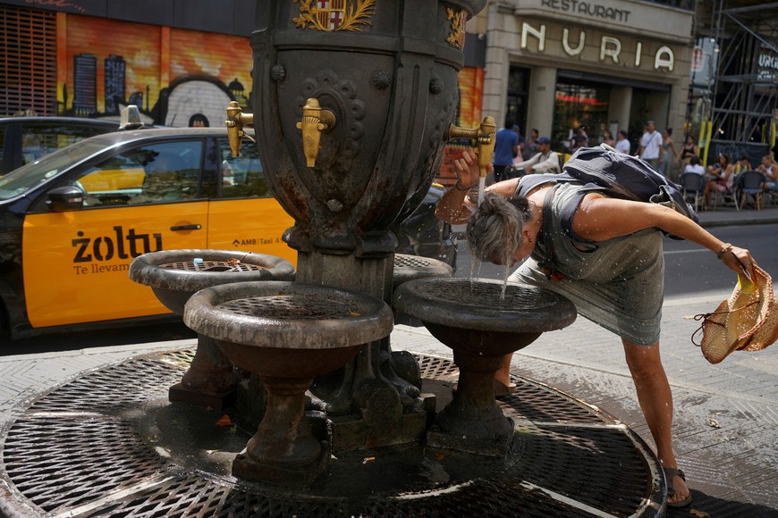 A tourist cools herself in a fountain amid a heatwave at Las Ramblas in Barcelona, while Europe is on red alert as heatwaves bring health warnings, Spain July 19, 2023. REUTERS/Bruna Casas  NO RESALES. NO ARCHIVES     TPX IMAGES OF THE DAY