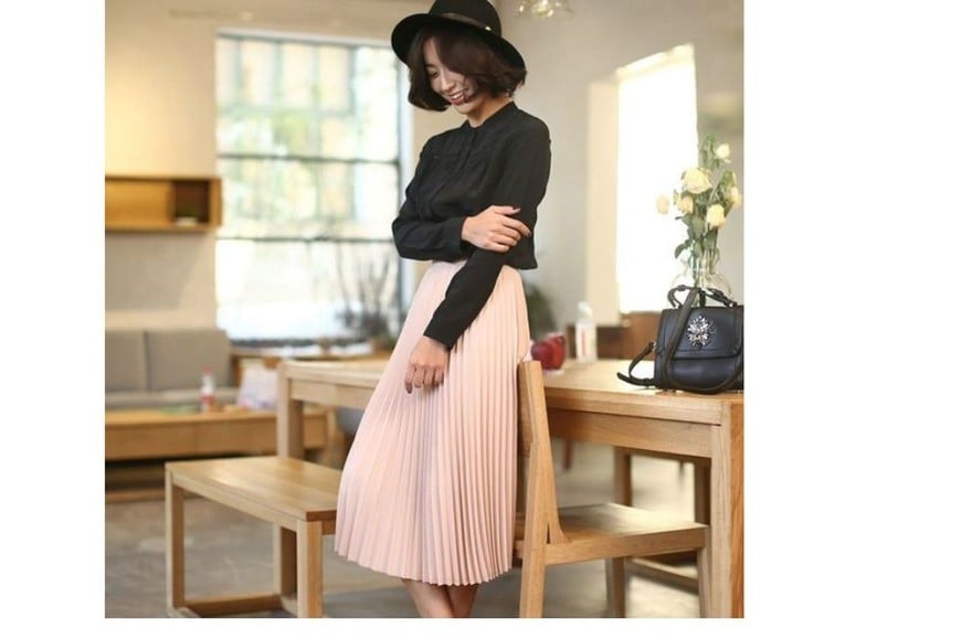 Una falda plisada en rosa con un suéter gris es un look súper trendy.