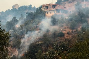 Smoke rises from a forest fire in the mountainous Tizi Ouzou province, east of the Algerian capital, Algiers, August 10, 2021.  REUTERS/Abdelaziz Boumzar