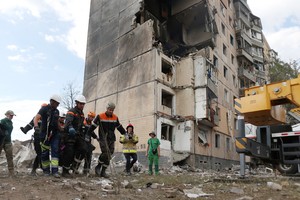 Los rescatistas llevan el cuerpo de un residente recuperado después de que un edificio residencial de nueve pisos fuera parcialmente destruido como resultado del ataque con misiles rusos en Kryvyi Rig.