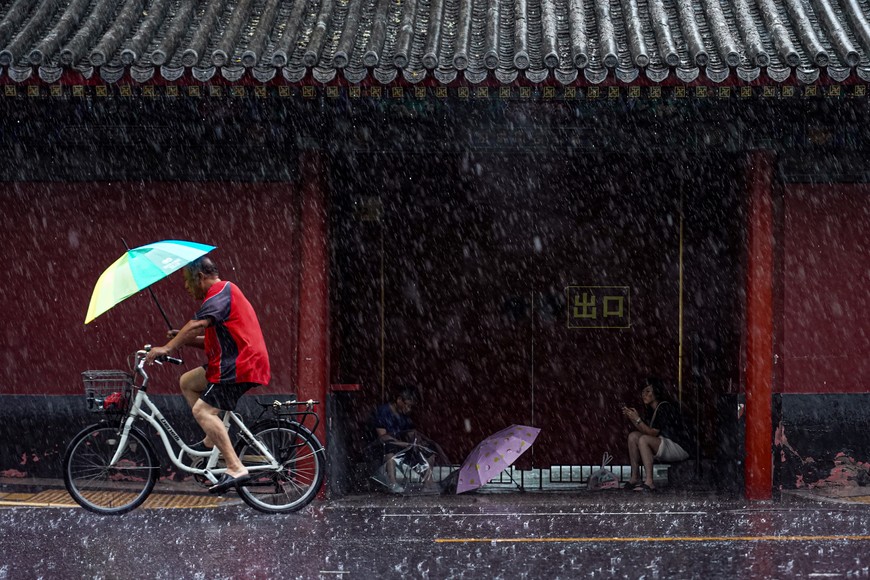 (230730) -- BEIJING, 30 julio, 2023 (Xinhua) -- Un hombre monta en bicicleta en medio de la lluvia, en Beijing, capital de China, el 30 de julio de 2023. Regiones del norte de China, incluidas Beijing, Hebei y Shandong, han sido azotadas por las fuertes lluvias causadas por el tifón Doksuri, el quinto de este año. (Xinhua/Chen Zhonghao) (oa) (ah) (da)