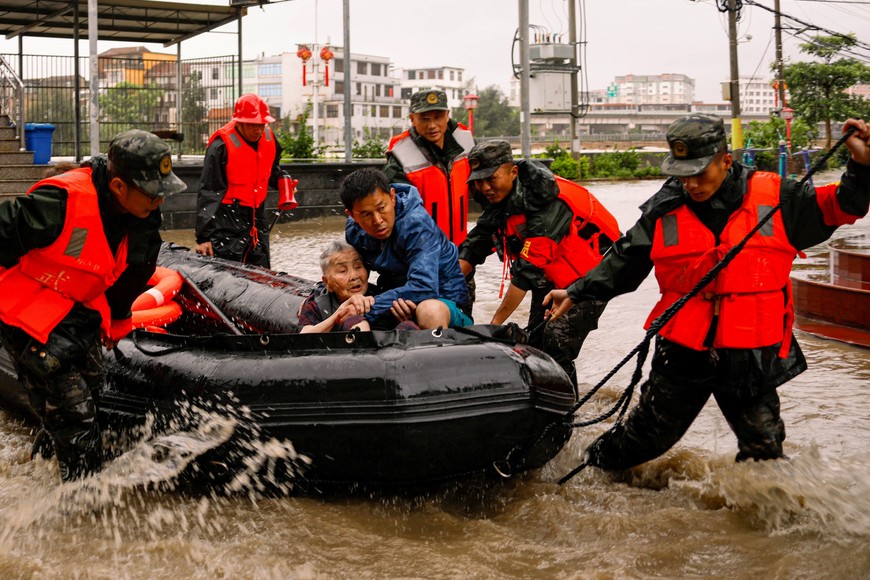 Paramilitary police officers evacuate residents stranded by floodwaters in Xincuo town of Fuqing city, after Typhoon Doksuri made landfall and brought heavy rainfall in Fuzhou, Fujian province, China July 29, 2023. cnsphoto via REUTERS   ATTENTION EDITORS - THIS IMAGE WAS PROVIDED BY A THIRD PARTY. CHINA OUT.