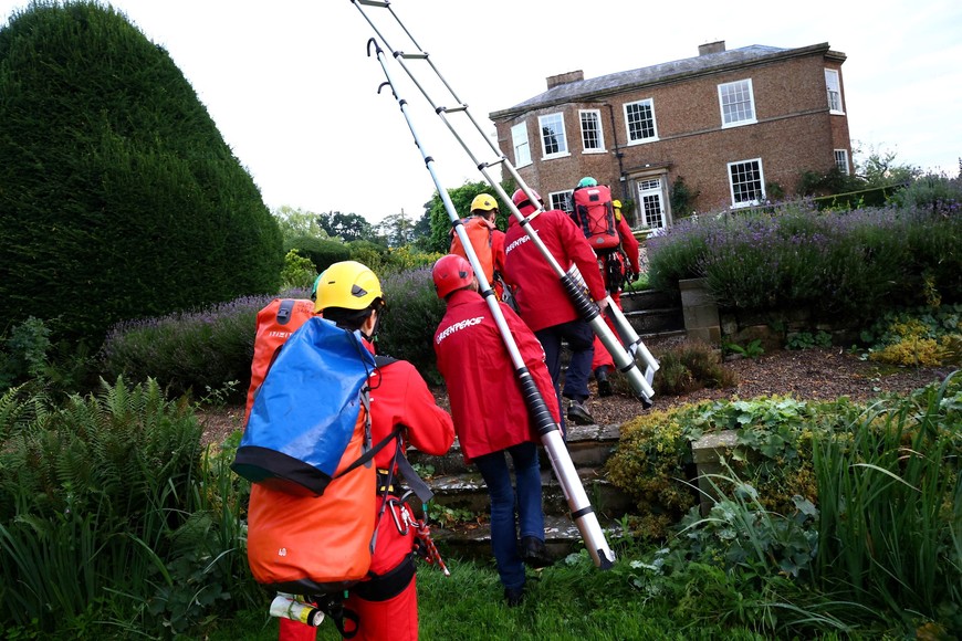 Greenpeace activists walk to climb onto the roof of British Prime Minister Rishi Sunak's £2m manor house to cover it with oil-black fabric in protest of his backing for a major expansion of North Sea oil and gas drilling amidst a summer of escalating climate impacts, in Yorkshire, Britain August 3, 2023. Greenpeace/Handout via REUTERS    THIS IMAGE HAS BEEN SUPPLIED BY A THIRD PARTY. NO RESALES. NO ARCHIVES. MANDATORY CREDIT. NO USE AFTER AUGUST 17, 2023.