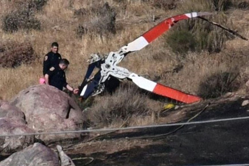 Autoridades inspeccionan partes del helicóptero caído.