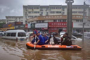 Rescue workers in a boat go through a flooded street in a neighbourhood where days of heavy rain from remnants of Typhoon Doksuri cause heavy damage in Beijing, China, August 1, 2023. REUTERS/Thomas Peter     TPX IMAGES OF THE DAY
