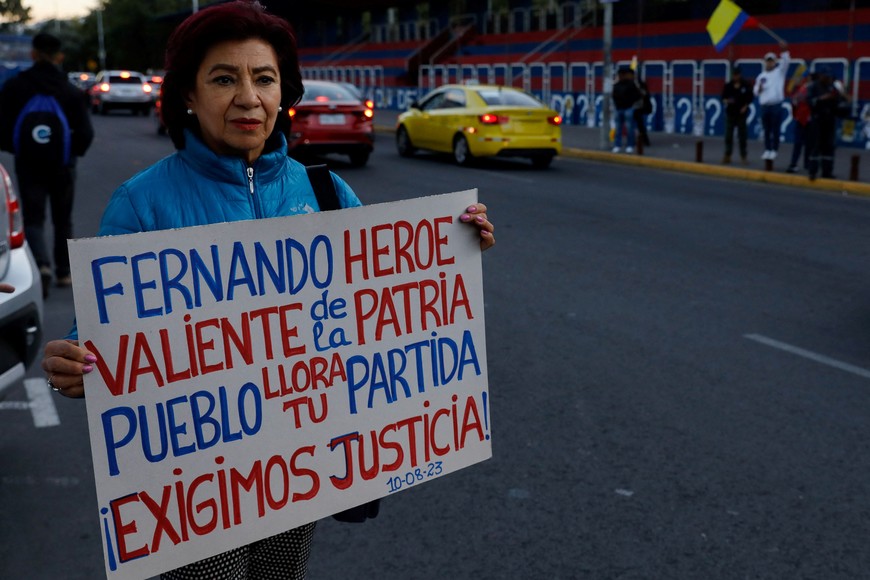 A woman holds a sign during a demonstration following the killing of Ecuadorean presidential candidate Fernando Villavicencio, a vocal critic of corruption and organized crime who was killed during a campaign event, in Quito, Ecuador, August 10, 2023. REUTERS/Karen Toro