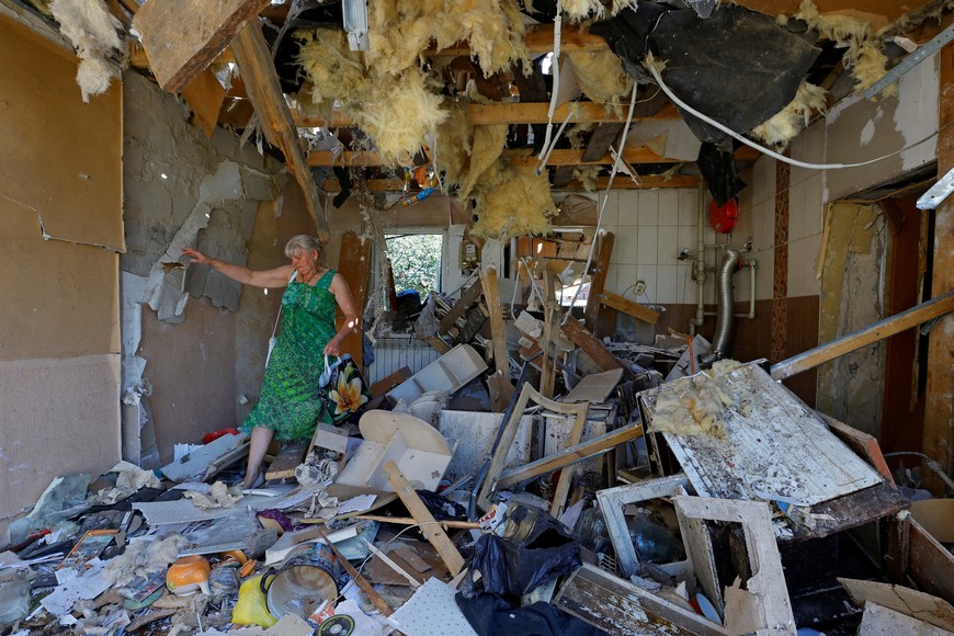 Lyubov Tolchina, 63, walks through the damaged house of her son Vitaly, 40, who was killed the day before by shelling in the course of Russia-Ukraine conflict in Donetsk, Russian-controlled Ukraine, August 13, 2023. REUTERS/Alexander Ermochenko