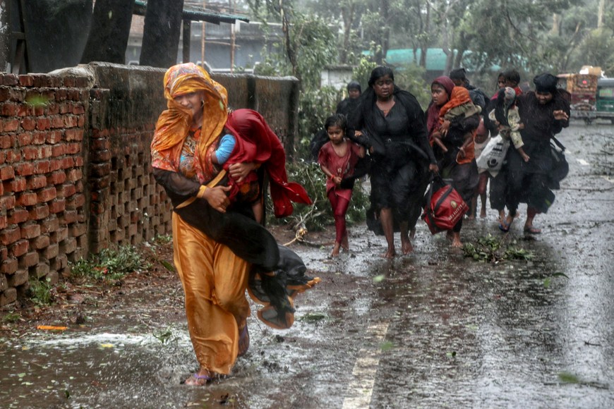 People move from their homes to take shelter in the nearest cyclone shelter at Shah Porir Dwip during the landfall of cyclone Mocha in Teknaf, Bangladesh, May 14, 2023. REUTERS/Jibon Ahmed NO RESALES. NO ARCHIVES     TPX IMAGES OF THE DAY