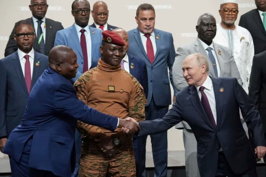 El presidente ruso Vladímir Putin saludando a su homólogo de Mozambique, Filipe Nyusi, con Traoré en el centro, antes de la foto oficial.