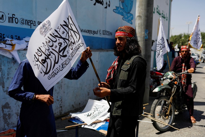 A Taliban member holds an Islamic Emirate of Afghanistan flag on the second anniversary of the fall of Kabul on a street near the US embassy in Kabul, Afghanistan, August 15, 2023. REUTERS/Ali Khara