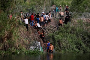 Migrants cross the Rio Bravo river to turn themselves in to U.S. Border Patrol agents before Title 42 ends, in Matamoros, Mexico May 10, 2023. REUTERS/Daniel Becerril     TPX IMAGES OF THE DAY