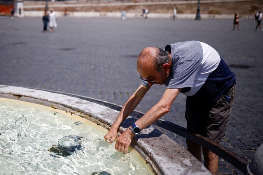 A man called Alfonso who did not want to give his surname, cools off at a fountain at Piazza del Popolo, during a heatwave across Italy, in Rome, Italy, July 14, 2023. REUTERS/Guglielmo Mangiapane