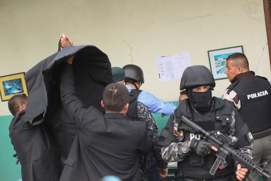Police officers cover Ecuadorian presidential candidate Christian Zurita as he arrives to vote at a polling station during the presidential election, in Quito, Ecuador August 20, 2023. REUTERS/Henry Romero