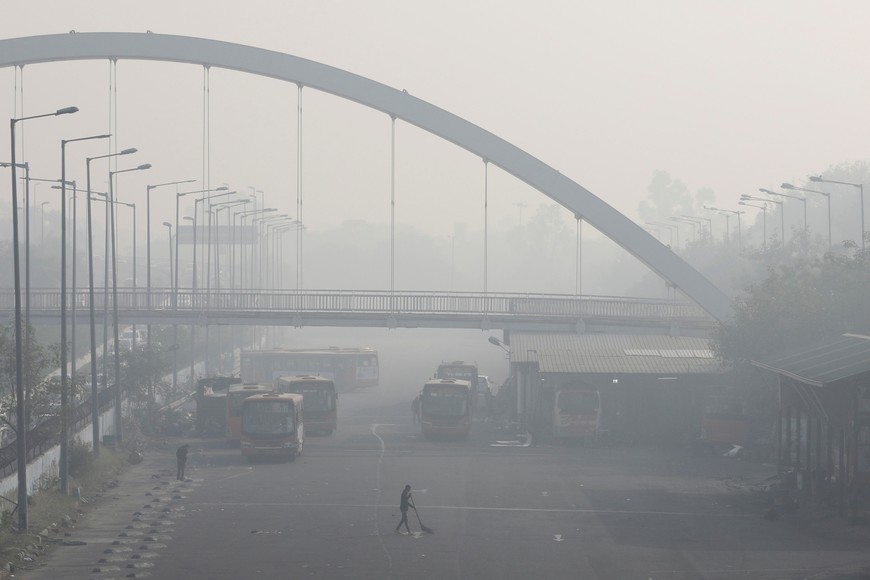 A man sweeps inside a bus depot on a smoggy morning in New Delhi, India, November 16, 2021. REUTERS/Anushree Fadnavis