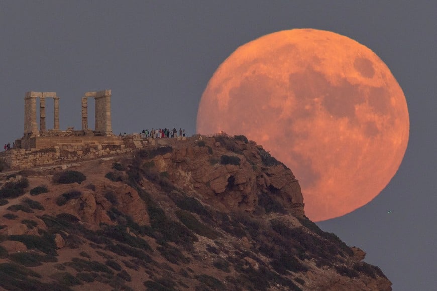 A full moon known as the "Blue Moon" rises behind the Temple of Poseidon, in Cape Sounion, near Athens, Greece, August 30, 2023. REUTERS/Stelios Misinas