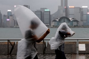 La gente desafía los fuertes vientos mientras se acerca el súper tifón Saola, en Hong Kong. Crédito: REUTERS. 