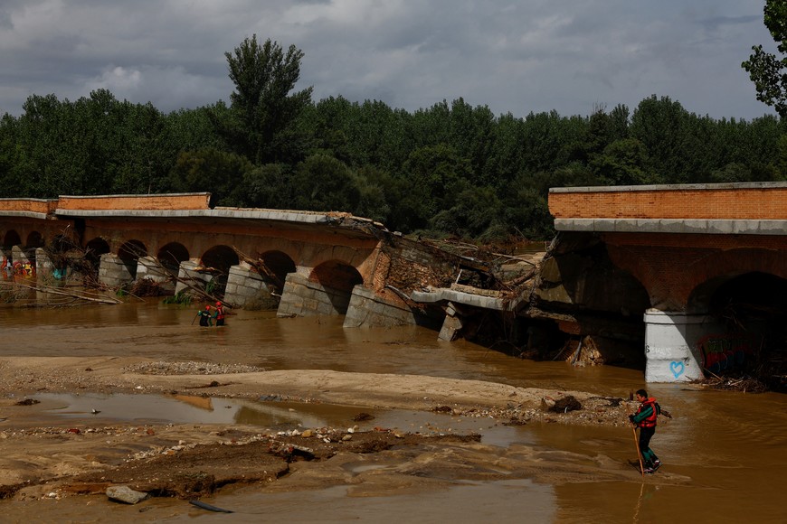 Members of the Spanish Civil Guard search and rescue team look for a missing person by a bridge that partially collapsed, following heavy rain in Aldea del Fresno, Spain September 4, 2023. REUTERS/Susana Vera