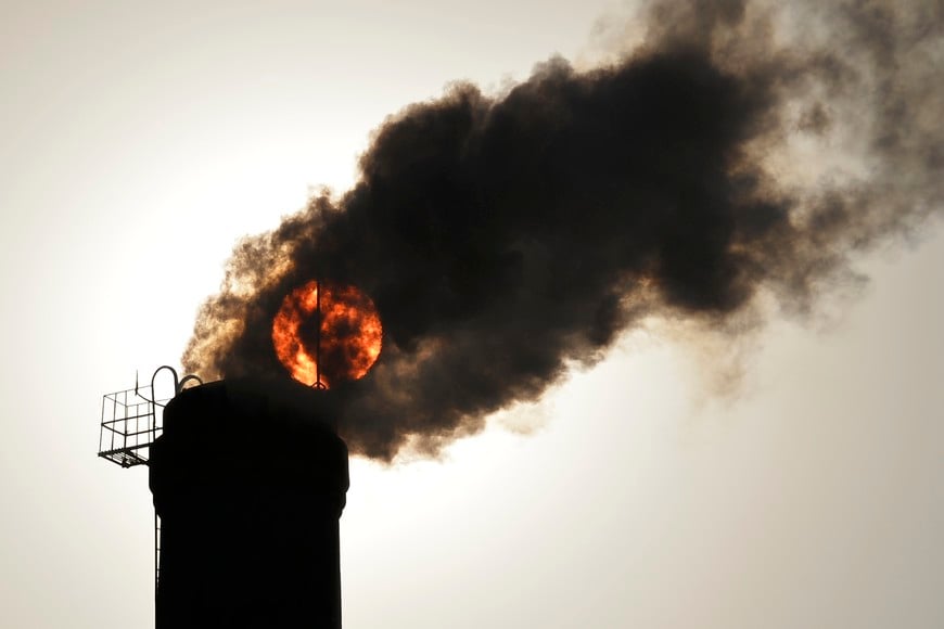 The sun is seen behind smoke billowing from a chimney of a heating plant in Taiyuan, Shanxi province in this December 9, 2013 file photo. The Beijing municipal government has proposed new rules that will set tight restrictions on offsets in its carbon market, aiming to avoid the fate of schemes in other countries where a glut of offsets has undermined carbon prices. The capital is one of six Chinese cities and provinces that have launch CO2 trading markets to help the world's biggest-emitting nation slow its rapid growth in climate-changing greenhouse gas emissions. REUTERS/Stringer (CHINA - Tags: ENVIRONMENT POLITICS ENERGY SOCIETY) CHINA OUT. NO COMMERCIAL OR EDITORIAL SALES IN CHINA china chimenea de una central termica nubes de humo negro nube fuertes restricciones a las compensaciones en su mercado de carbono