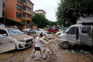 Un niño camina por una calle embarrada después de que fuertes lluvias inundaran la Guangdong, China.
Crédito: REUTERS.
