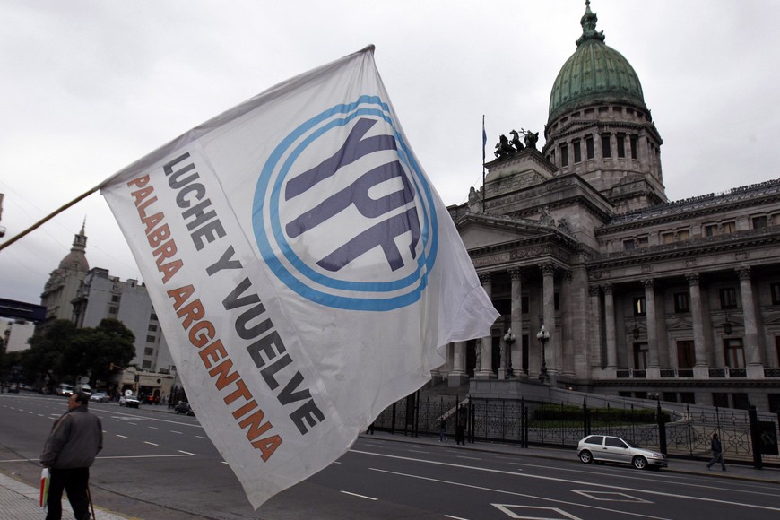 man waves a flag with the YPF logo in front of the Argentine Congress in Buenos Aires April 25, 2012. Argentine senators on Wednesday were set to approve the nationalization of YPF, the country's biggest oil company, underscoring broad domestic support for a move that sparked outrage among foreign investors and trade partners. President Cristina Fernandez de Kirchner, who controls both houses of Congress, unveiled plans last week to seize a controlling 51 percent stake of YPF from Spain's Repsol. REUTERS/Marcos Brindicci (ARGENTINA - Tags: POLITICS ENERGY) buenos aires  debate camara alta senadores senado nacional expropiacion el 51 por ciento de las acciones de la petrolera YPF carteles manifestantes apoyo