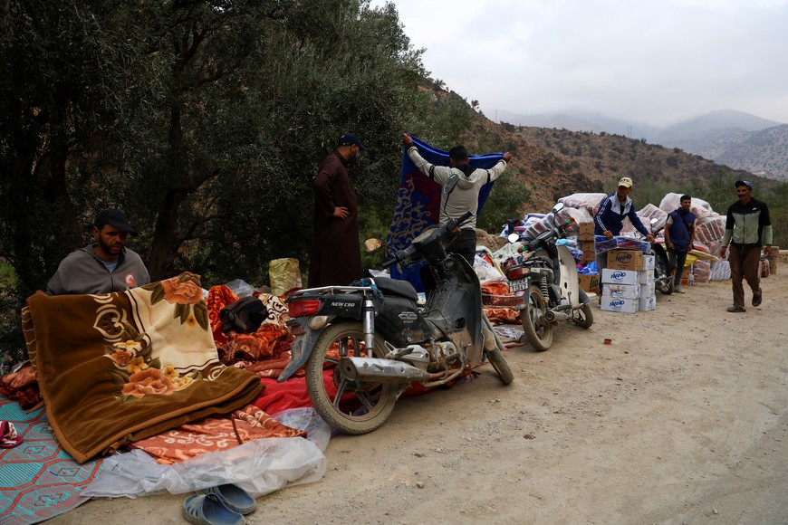 A group of people stand along the Tizi n'Test Road that connects parts of the High Atlas Mountains in the Al Haouz province with Marrakech, in the aftermath of a deadly earthquake in Morocco September 12, 2023. REUTERS/Hannah McKay