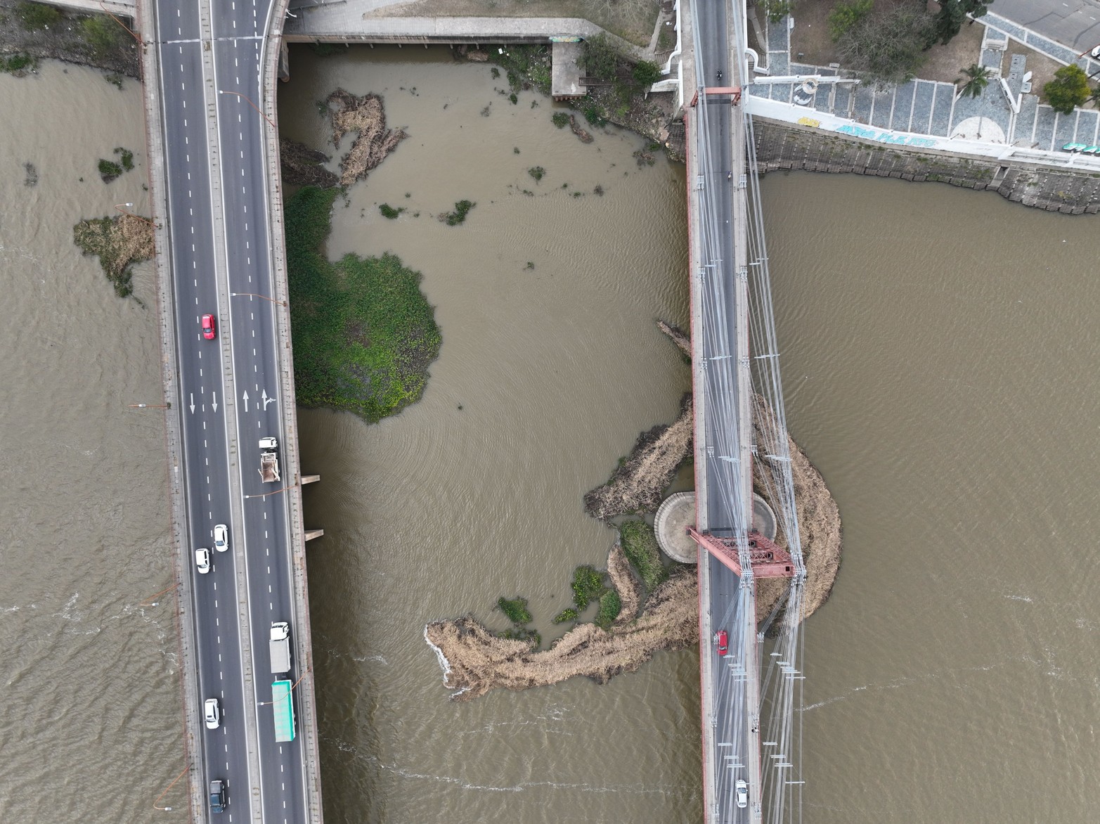 A los camalotes se los lleva el viento. Los fuertes vientos del lunes pasado movieron el bloque de embalsados que se encontraba entre los pilotes del ex puente ferroviario de la Laguna Setúbal. Parte de esta "isla de camalotes" quedó ahora junto a la base del Puente Colgante.