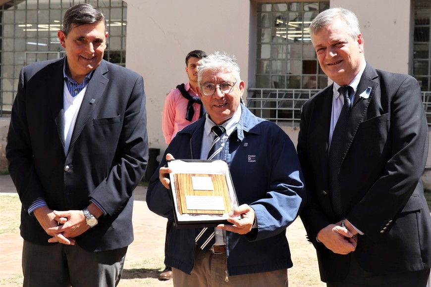 El rector De Palma y el presidente del Directorio De Feo entregaron una placa al hoy presidente de ADUCSF, Eduardo Quintana.