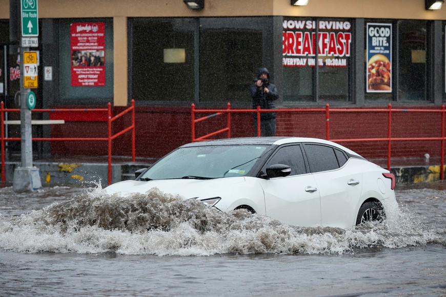 A car drives along a flooded street, as the remnants of Tropical Storm Ophelia bring flooding across mid-Atlantic and Northeast, in the Brooklyn borough of New York City, U.S., September 29, 2023.  REUTERS/Brendan McDermid