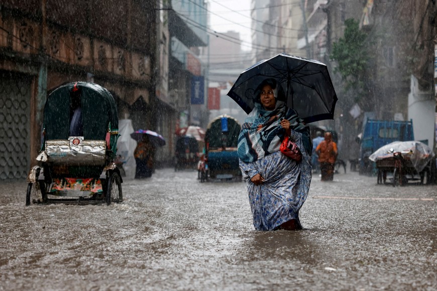 A woman holds an umbrella while walking along a flooded street during heavy rain in Dhaka, Bangladesh, June 12, 2023. REUTERS/Mohammad Ponir Hossain     TPX IMAGES OF THE DAY