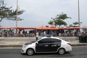 Police officers patrol next to a beachside food stand in Barra da Tijuca neighborhood where, according to a police's statement, physician Diego Ralf Bomfim, the brother of leftist lawmaker Samia Bomfim, was shot dead with his colleagues in a shooting, in Rio de Janeiro, Brazil, October 5, 2023. REUTERS/Ricardo Moraes