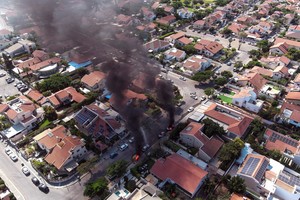 An aerial view shows vehicles on fire as rockets are launched from the Gaza Strip, in Ashkelon, southern Israel October 7, 2023. REUTERS/Ilan Rosenberg     TPX IMAGES OF THE DAY