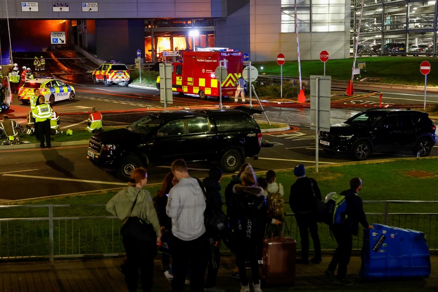 People leave the London Luton airport as emergency services respond to a fire in the Terminal Car Park 2, in Luton, Britain, October 11, 2023.  REUTERS/Peter Cziborra