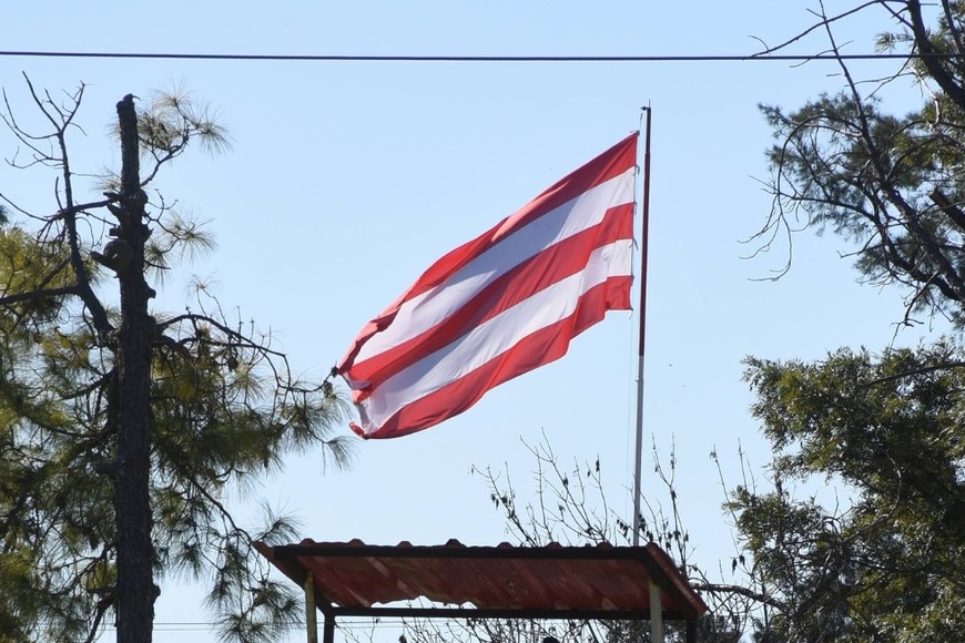 ¿Hace bandera el Tate?. La rojiblanca que flamea en el histórico predio de La Tatenguita, a la vera de la Autopista Santa Fe-Rosario. Una vez más, el Mundo Unión se ilusiona con el famoso predio propio. Con la plata de Machuca, el sueño podría ser realidad. Crédito: Luis Cetraro
