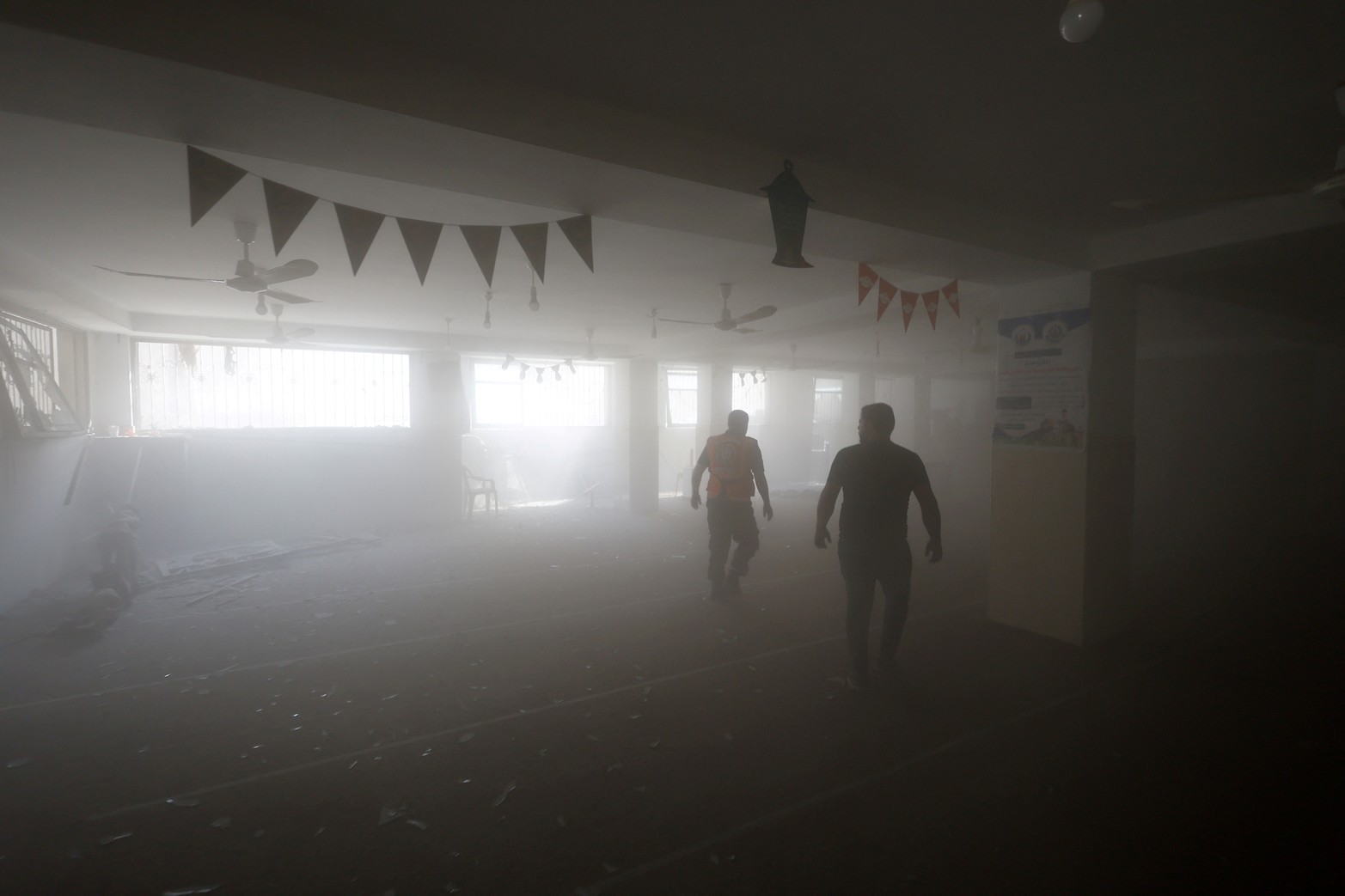 Hombres palestinos caminan dentro de una mezquita dañada por los ataques israelíes, en Khan Younis, en el sur de la Franja de Gaza.