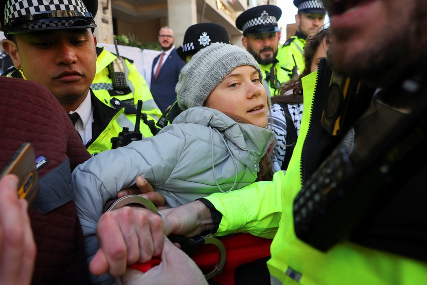 A police officer uses a pair of handcuffs on a climate activist, as Swedish climate campaigner Greta Thunberg is detained, during an Oily Money Out and Fossil Free London protest in London, Britain, October 17, 2023. REUTERS/Toby Melville