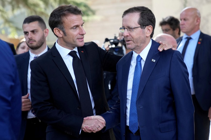 French President Emmanuel Macron, left, shakes hands with Israel's President Isaac Herzog after their talks in Jerusalem, Tuesday, Oct. 24, 2023. Emmanuel Macron is traveling to Israel to show France's solidarity with the country and further work on the release of hostages who are being held in Gaza.      Christophe Ena/Pool via REUTERS
