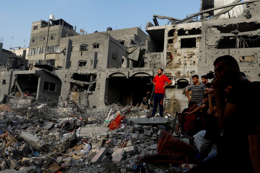 Palestinians look on during a search for casualties at the site of Israeli strikes on houses, in Khan Younis, in the southern Gaza Strip, October 25, 2023. REUTERS/Ibraheem Abu Mustafa