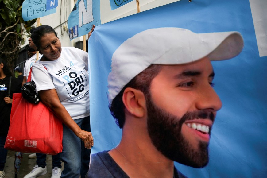 FILE PHOTO: A person holds a poster with a picture of El Salvador’s President Nayib Bukele, during a campaign rally of the Nuevas Ideas party in San Salvador, El Salvador, October 20, 2023. REUTERS/Jose Cabezas/File Photo