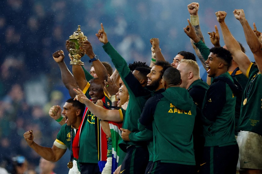 Rugby Union - Rugby World Cup 2023 - Final - New Zealand v South Africa - Stade de France, Saint-Denis, France - October 28, 2023 
South Africa's Siya Kolisi lifts The Webb Ellis Cup with teammates and South African president Cyril Ramaphosa as they celebrate winning the world cup final REUTERS/Sarah Meyssonnier