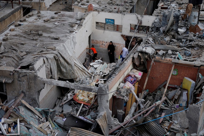 Palestinians check the damage at the site of Israeli strikes on houses, amid the ongoing conflict between Israel and Palestinian Islamist group Hamas, in Khan Younis in the southern Gaza Strip, October 29, 2023. REUTERS/Mohammed Salem     TPX IMAGES OF THE DAY