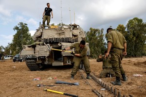 Israeli soldiers carry out maintenance on an Israeli tank near Israel's border with the Gaza Strip, in southern Israel October 15, 2023. REUTERS/Amir Cohen     TPX IMAGES OF THE DAY