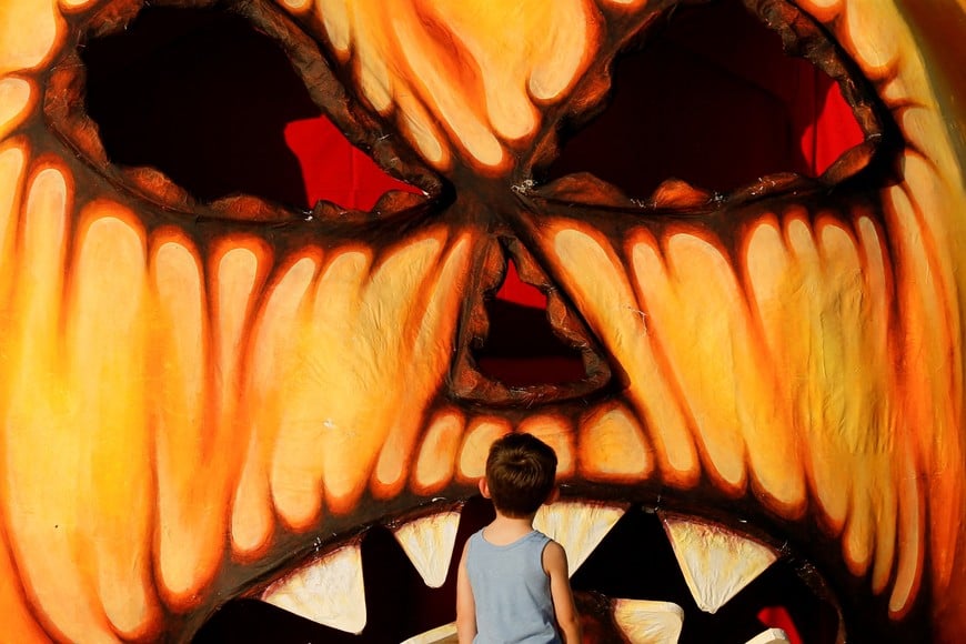 A kid looks at a giant Halloween pumpkin made from papier-mache in Valletta, Malta, October 24, 2022.  REUTERS/Darrin Zammit Lupi


     TPX IMAGES OF THE DAY