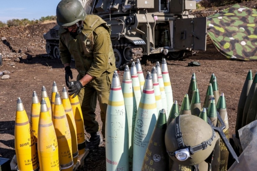Un soldado del ejército israelí ajusta la punta de un proyectil de artillería de 155 mm cerca de un obús autopropulsado desplegado en una posición cerca de la frontera con el Líbano en la región de la Alta Galilea, en el norte de Israel, el 18 de octubre de 2023.. Crédito: Jalaa Marey