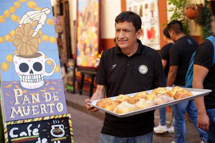 (231031) -- GUANAJUATO, 31 octubre, 2023 (Xinhua) -- Imagen del 29 de octubre de 2023 de un hombre ofreciendo pan de muerto en una calle en el marco de la celebración del Día de Muertos, en Guanajuato, México. (Xinhua/Francisco Cañedo) (fc) (oa) (vf)
