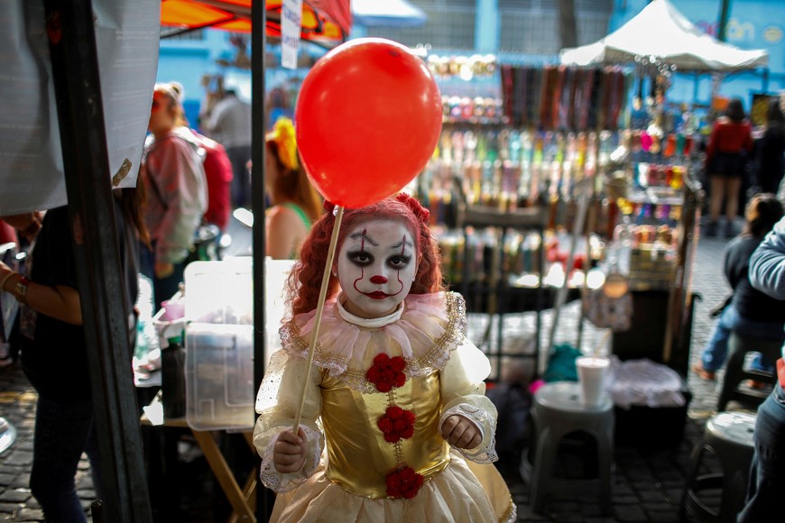 A girl dressed in a costume poses for a picture at a street market during the Day of the Dead celebrations, in Mexico City, Mexico November 1, 2023. REUTERS/Raquel Cunha