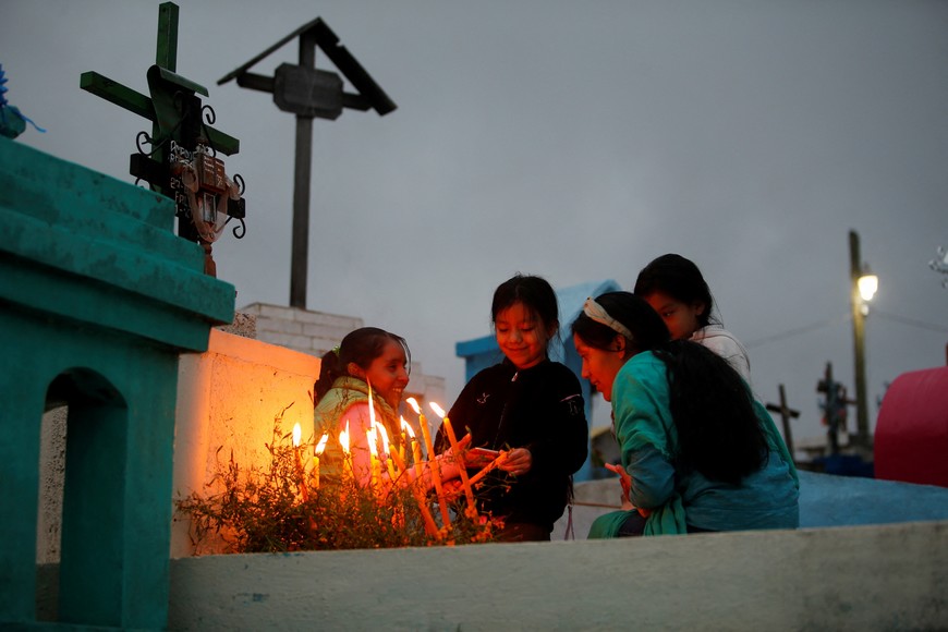 People light candles on deceased children's graves during the annual "Feast of the Ancestors" celebration as part of the Day of the Dead festivities, in Mazatlan Villa de Flores, Mexico, November 1, 2023. REUTERS/Jorge Luis Plata