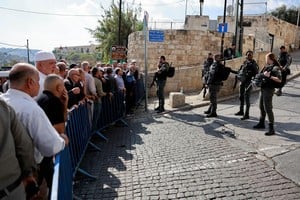 Soldados israelíes hacen guardia mientras los fieles musulmanes esperan para entrar a la mezquita de Al Aqsa, en Jerusalén.